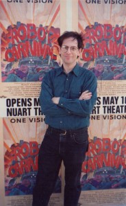 Jerry Beck stands in front of a wild posting of ROBOT CARNIVAL posters  in late April 1991