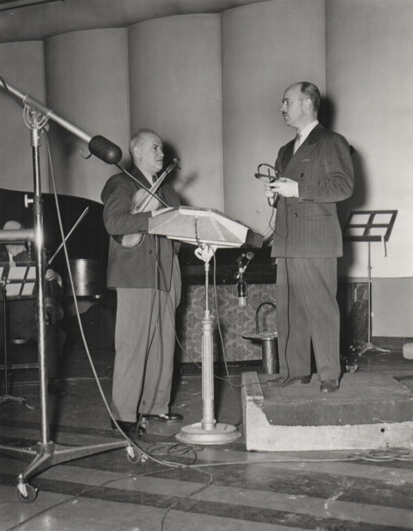 Winston Sharples (right) confers with his violinist. 